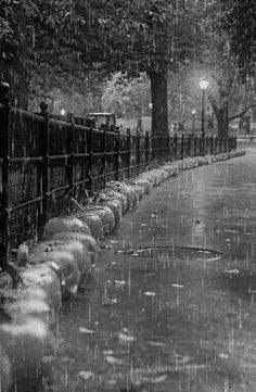 black and white photograph of people walking in the rain