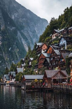 houses on the shore of a lake with mountains in the background