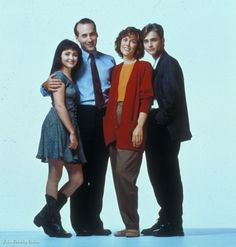 the cast of modern family posing for a photo in front of a blue background with one man and two women