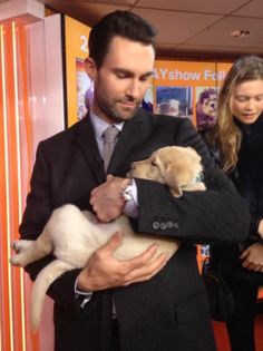 a man in a suit holding a puppy