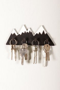 five keys hanging on a wall with mountains in the background