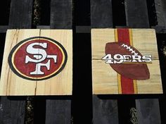 three wooden signs depicting different sports logos on wood planks with grass in the background