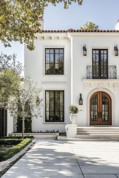 a large white house with lots of windows and steps leading to the front door area