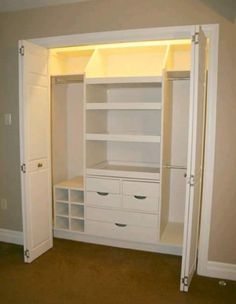 an empty closet with white shelves and drawers