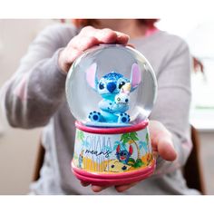 a person holding a snow globe with an image of stitchy the stitcher in it