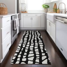 a black and white rug in the middle of a kitchen