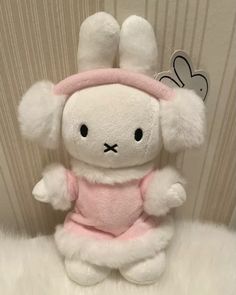 a white stuffed rabbit wearing a pink outfit