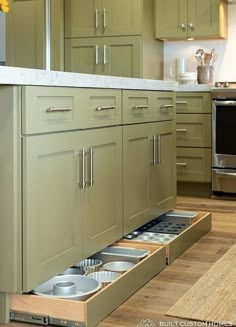 an open drawer in the middle of a kitchen