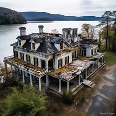 an old abandoned house sitting on the side of a lake