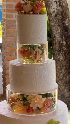 three tiered wedding cake with flowers on top