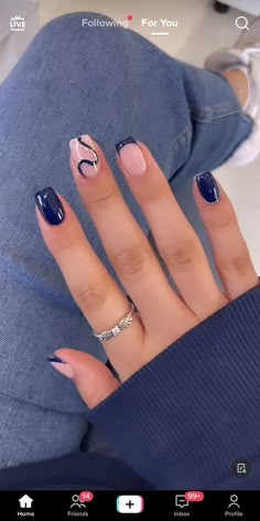 a woman's hand with blue and white manicures on it, while she is