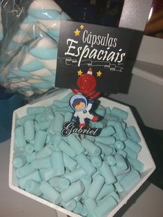 some blue and white candies are in a bowl on a table with a sign that says cupcakes espaginais