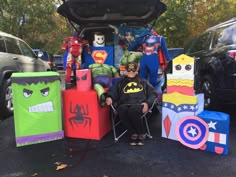 a woman sitting in a chair next to some superheros and spider - man cubes