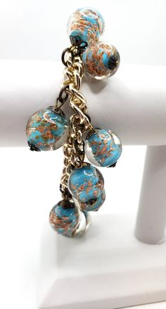 "These beads do not belong on this bracelet, but this is how I found it in an estate purchase. Beautiful vintage murano glass venetian beads of Robin egg blue color infused with gold or copper dust. Brass findings shaped like a flower petal. 14 beads in total. Each bead is over .5\" in diameter.  These would be beautiful restrung into a necklace.  I acquired this from an estate of someone who obviously loved and collected fine vintage jewelry and antiques. As with any vintage item, this piece may have evidence of handling and prior love - including minor or light scratches, oxidation, patina and other blemishes." Vintage Gold Glass Bracelets, Unique Gold Beaded Glass Bracelets, Vintage Gold Czech Glass Bracelets, Robin Egg Blue, Flower Petal, Venetian Glass, Robins Egg Blue, Beads Jewelry, Flower Petals