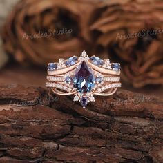 an engagement ring with two rows of blue and white stones on it, set in 18k rose gold