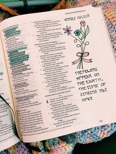 an open bible laying on top of a crocheted blanket