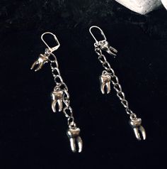 These earrings feature a dangling curb style chain with 3 tooth charms. Lever back style clasp Silver toned metals Handmade with love 🖤 **check out the matching necklace also in my store** Punk Dangle Jewelry For Alternative Fashion, Hypoallergenic Punk Dangle Earrings, Hypoallergenic Dangle Earrings In Punk Style, Silver Metal Emo Earrings, Silver Metal Emo Style Earrings, Silver Earrings For Alternative Fashion, Nickel Free Silver Emo Earrings, Punk Dangle Jewelry With Adjustable Chain, Nickel-free Silver Emo Earrings