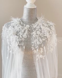 a mannequin wearing a white veil with flowers on it's neckline