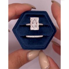 a woman holding an engagement ring in a velvet box with diamonds on it's sides