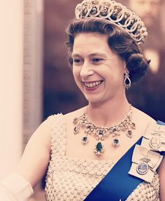 an older woman wearing a tiara and smiling