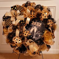 the wreath is decorated with black and gold ribbons