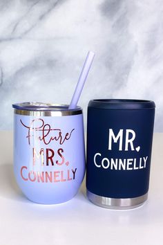 two personalized coffee mugs one is blue and the other is white with pink lettering