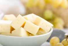 grapes and cheese in a bowl on a table