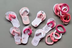 several pairs of flip flops with pink, white and pink rubber bands on them