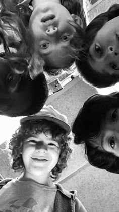 four children are standing in a circle with their mouths open and looking up at the camera