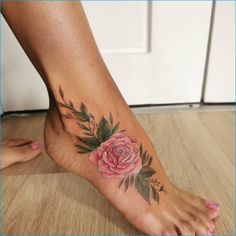 a woman's foot with a rose tattoo on it