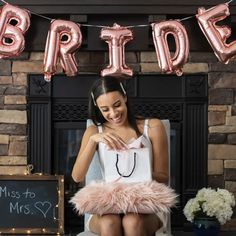 a woman sitting on top of a chair in front of a sign that says bride