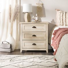 a bedroom scene with focus on the nightstand and bed side table, rugs and lamps