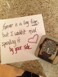 a note with a watch in it next to a pen and some paper on the counter