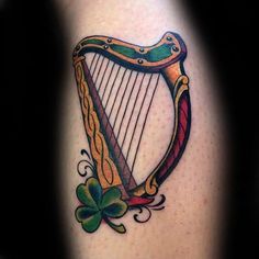 a tattoo with a harp and shamrocks on it