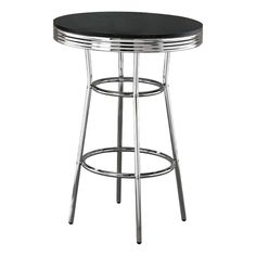 a black counter top with chrome barstools and a round metal table on the bottom