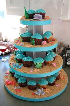 a three tiered cake with cupcakes on the bottom and under each tier