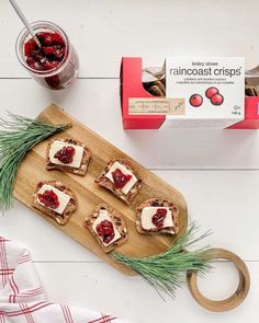 some food is sitting on a cutting board next to a box of cranberry cheese