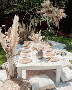 an outdoor table set up for a party with white and brown decorations on top of it