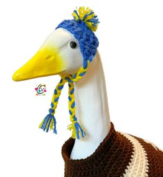 a white duck wearing a blue and yellow knitted hat on top of a mannequin's head