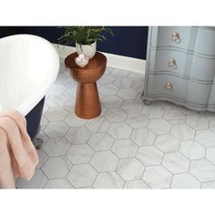 a bath tub sitting next to a white toilet in a room with blue walls and flooring