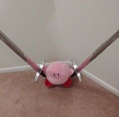 a pink stuffed animal with two swords in its mouth and on it's back