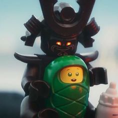 a lego figure holding a baby bottle with an evil demon on it's back