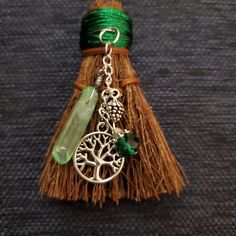 a tassel with an owl and tree charm on it