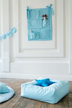 a blue dog bed sitting on top of a wooden floor next to a white wall