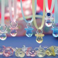 several different colored glass beads are hanging from a string on a blue tablecloth with other items in the background