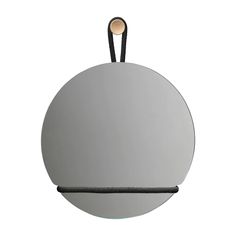 a round mirror hanging on a black cord