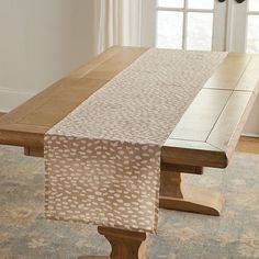 a wooden table with an animal print runner on it