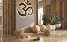 a yoga studio with wooden floors and large sculptures on the wall behind it, along with potted plants