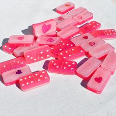 pink dices with hearts on them sitting on a white tableclothed surface,