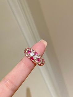 This charming ruby ring, with its sweet macaron-inspired colors, combines vintage polka dots with a fresh, vibrant twist. The ring features a mix of diamonds set in a staggered pattern for a layered look and a heart-shaped lattice design underneath. Handcrafted from 925 sterling silver with a thick rose gold plating, it shines beautifully and adds a playful elegance to any outfit. Metal: 18K Recycled Gold Plated Vermeil on Recycled Sterling Silver Gemstone: Cubic Zirconia/Ruby Red/Paraiba Blue Ring Sizes Available: 5, 6, 7, 8(US) Pink Ruby Ring For Valentine's Day, Pink Round Ruby Promise Ring, Pink Crystal Ring For Valentine's Day, Pink Ruby Open Ring With Gemstone, Pink Ruby Ring With Round Band, Pink Ruby Round Ring, Pink Gold Ruby Ring Gift, Valentine's Day Pink Ruby Ring, Pink Gold Rings For Valentine's Day